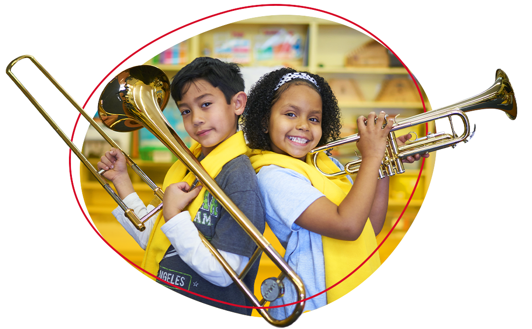 two grade school kids holding up musical instruments