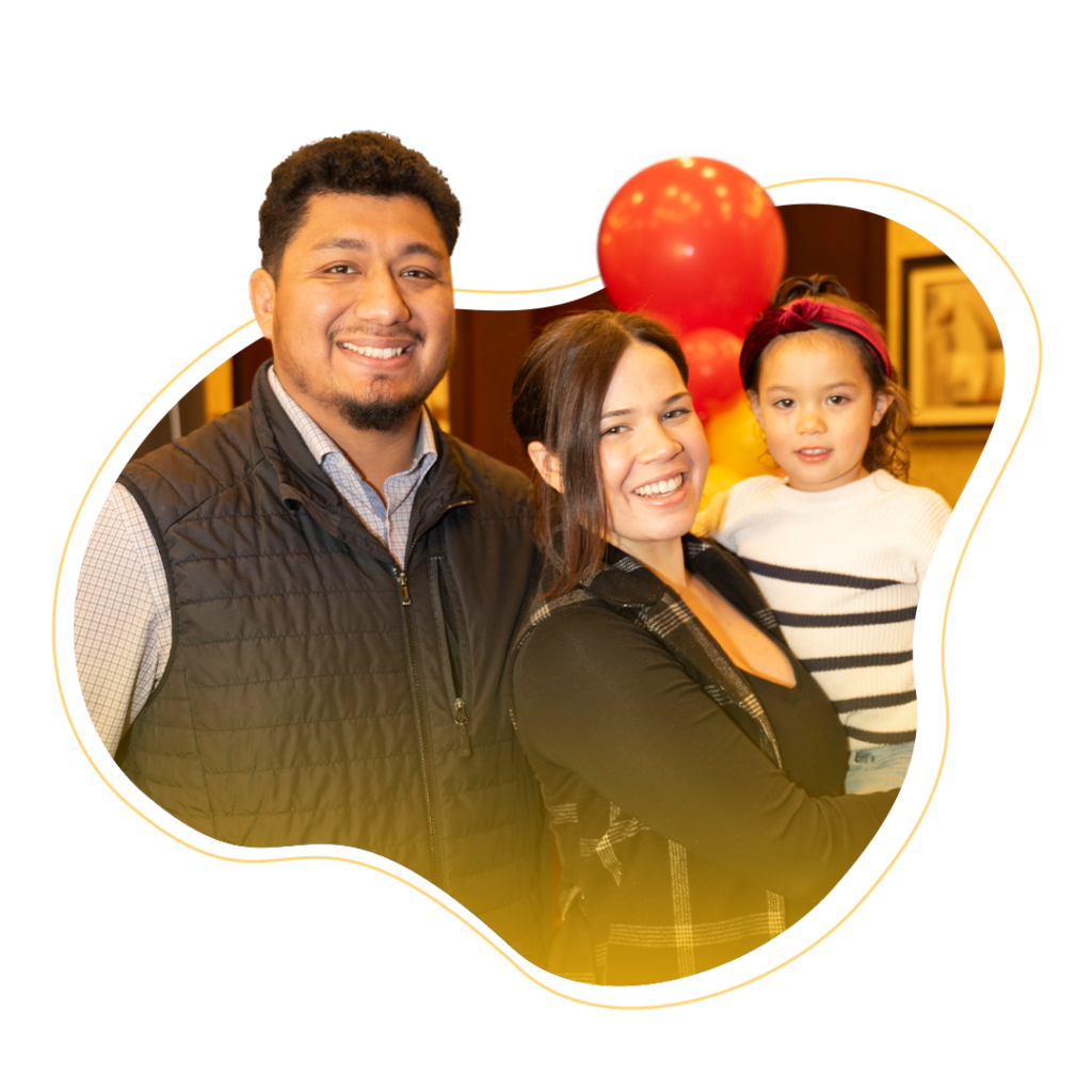 A father, mother, and daughter smiling