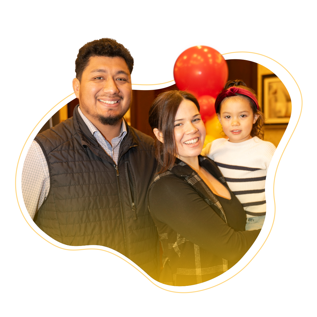 A father, mother, and daughter smiling